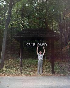 David Eisenhower standing under the sign for Camp David, which his grandfather named after him.